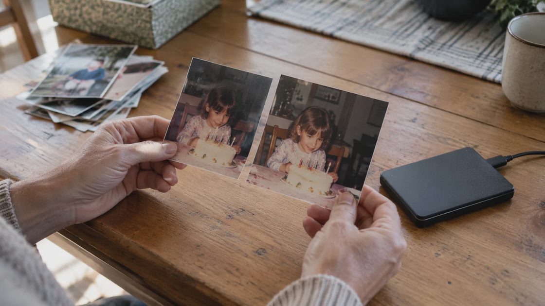 Cloud Photo Storage: Practical check Hands comparing two printed family photographs beside an external drive.